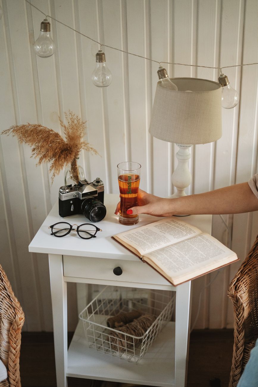 Bedside table with a warm lamp and an open book in the evening